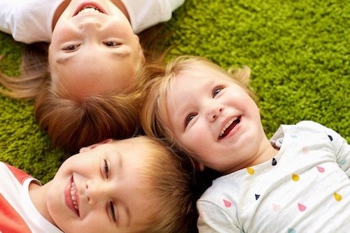 happy little kids lying on floor or carpet