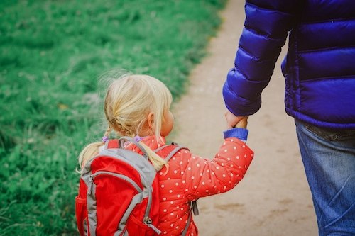 father walking little daughter to school or daycare