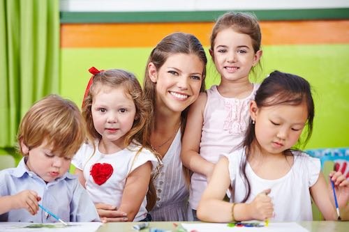 Erzieher und Kinder im Kindergarten malen