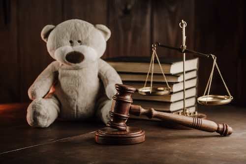 Divorce and alimony concept. Wooden gavel and teddy bear in notary public office